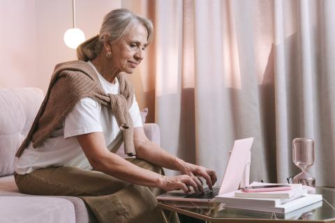 Mature woman searching for information on laptop